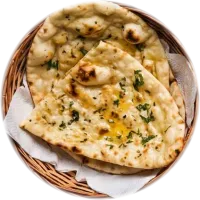 Buttery naan flecked with herbs in a paper-lined wicker basket