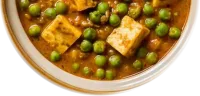 Green peas and paneer in a spiced tomato sauce, in a cream bowl