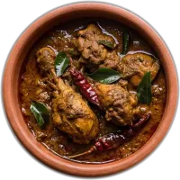 Dark dry-roasted chicken with curry leaves and dried red chillies in a terracotta pot